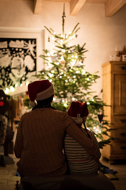 father and son looking at a Christmas tree