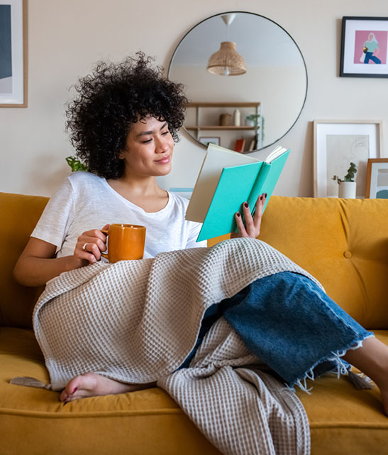 calm woman sitting on a couch and reading